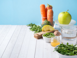 Healthy diet food on the table Arugula Green Beans Apple Water Honey Cracker Carrot Copy space