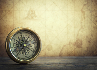 Old vintage retro compass on ancient map background. Travel geography navigation concept background.
