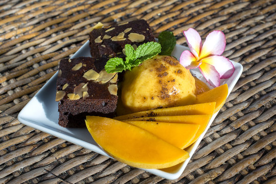 Fresh homemade organic mango ice cream sorbet with mint leaves and chocolate brownie , close up. Thailand