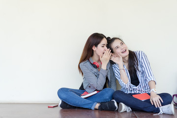 Teenagers women gossip girlfriend sharing secrets smiling sitting talking surprise in the ear, copy space background