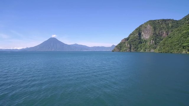 Aerial over Lake Amatitlan in Guatemala reveals the Pacaya Volcano in the distance.