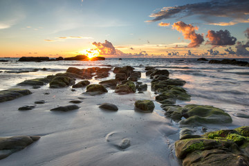 Serinity view of sunset seascape with natural coastal rocks on the beach.