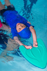 Boy having a swimming lesson with instructor