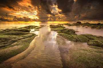 Serinity view of sunset seascape with natural coastal rocks on the beach.