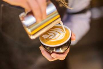 Hand on Barista making latte cafe, Cup of coffee with beautiful Latte art on cup