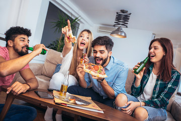 Group of young friends eating pizza.Home party.Fast food concept.