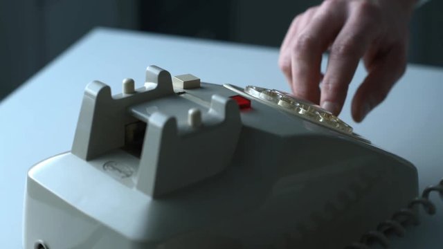 Businessman dialing a number on a vintage phone
