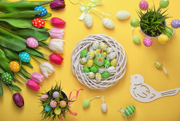 Easter eggs with colorful tulips on wooden background.Easter holiday concept. Easter decor.