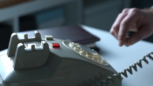 Businessman dialing a number on a vintage phone