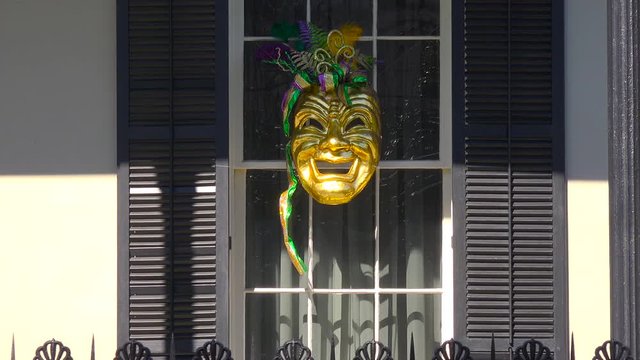 A Mardi Gras mask is displayed in a window in new Orleans.