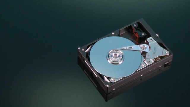 A hard drive without its cover rotates on display.