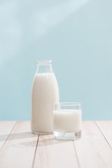 Dairy products. Bottle with milk and glass of milk on wooden table