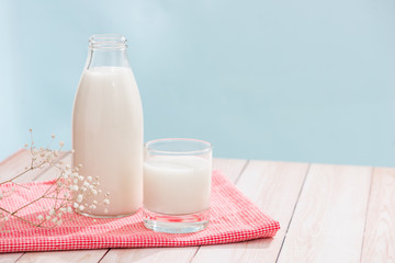 Dairy products. Bottle with milk and glass of milk on wooden table