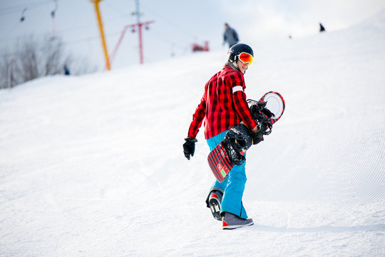 Photo from back of athlete walking with snowboard