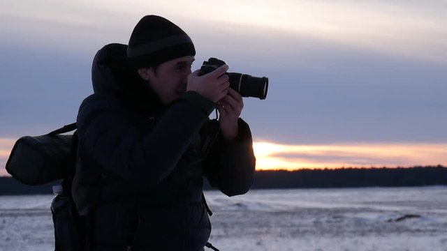 Silhouette of a nature photographer, taking pictures at sunset