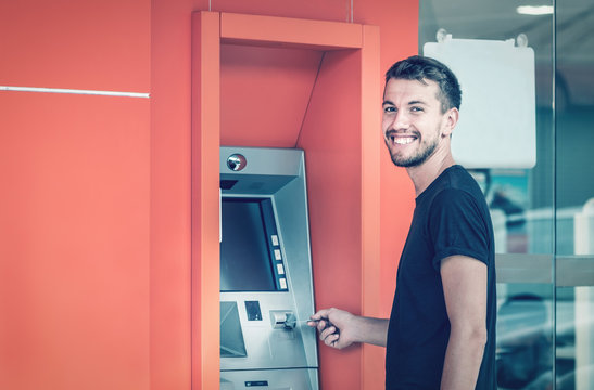 Young Smiling Man Using ATM Machine