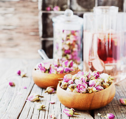 small dry buds of roses, tea, karkade, in wooden bowls, selective focus