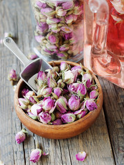 small dry buds of roses, tea, karkade, in wooden bowls, selective focus