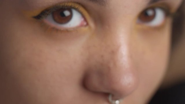 women's eyes with yellow eyeshadow closeup looking at camera