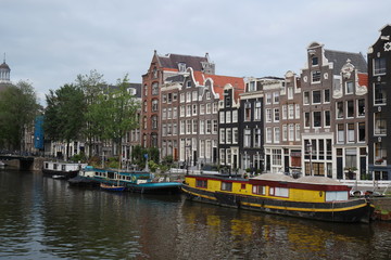 Fototapeta na wymiar Anciennes maison, péniches et canal à Amsterdam - Pays-Bas