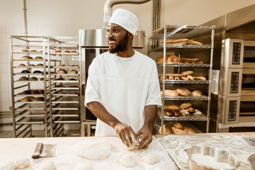 african american baker preparing raw dough for pastry on baking manufacture - Powered by Adobe