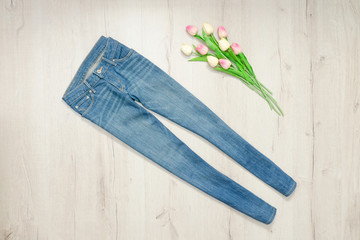 Blue jeans and bouquet of tulips. Fashionable concept