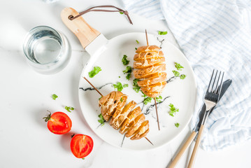 Tornado Cheesy Potatoes with Parsley and Tomatoes, on white marble background, copy space top view