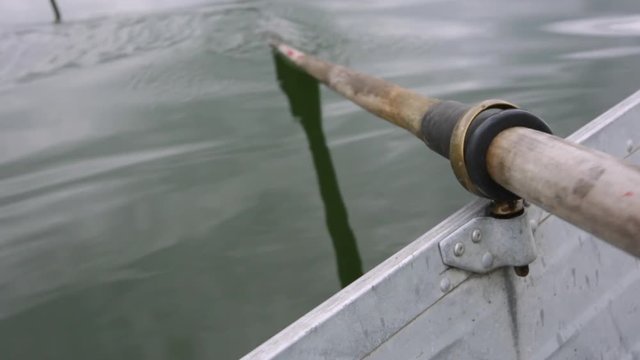 An oar rows a boat in slow motion.