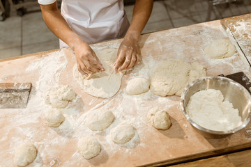 cropped shot of female baker kneading dough for pastry