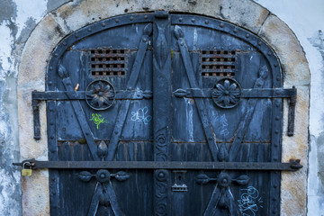 Detail of a metal gate. Rustic, corroded old blue door with a padlock in Szentendre, Hungary.