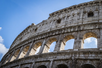 Fototapeta premium Ancient roman Colosseum detail in Rome, Italy, cloudy sky in background. Roman Colosseum exterior ruins. Unesco heritage site, Europe.