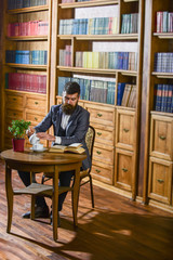 Aristocrat on thoughtful face reading book. Oldfashioned man holds cup