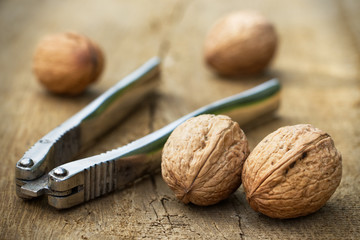 walnuts and a nutcracker on a wooden board 