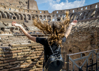 Detail of the historic Colosseum in Roma, Italy, teen girl from behind in the foreground.  Roman Colosseum interior ruins with a teen girl, Unesco heritage site, Europe. 