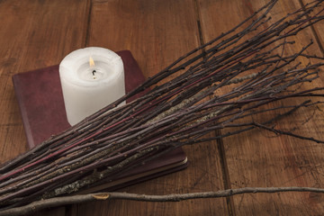 A photo of a handmade broom with a candle, a grimoire, and copy space