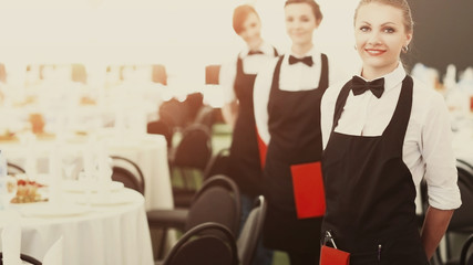 A large group of waiters and waitresses next to served tables