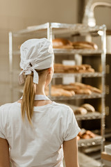 rear view of young female baker on baking manufacture