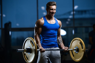 Naklejka na ściany i meble Handsome model young man workout in gym