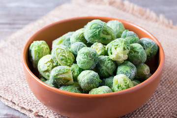 Frozen Brussels sprouts in a bowl on a wooden table