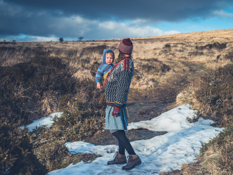 Young mother with baby on moor with snow
