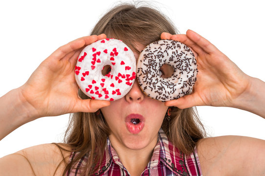 Attractive woman is holding donuts against her eyes