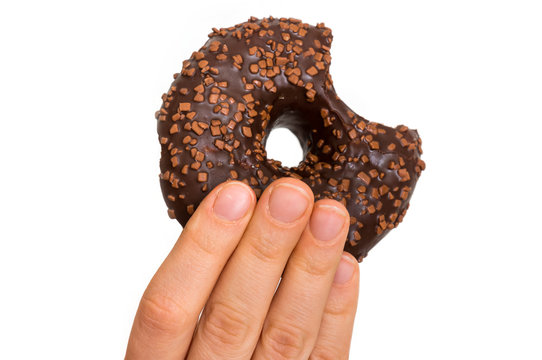 Female hand is holding donut with sprinkles
