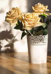 Beautiful bouquet of roses flowers in a white vase. Flowers in the rays of the morning light.