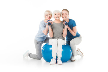 Three sportswomen with dumbbells and fitness ball isolated on white