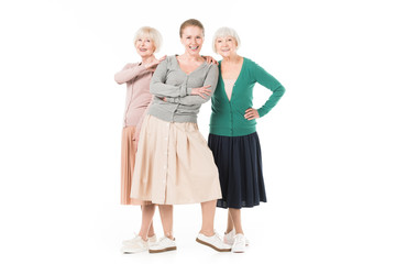 Three stylish women in skirts standing isolated on white