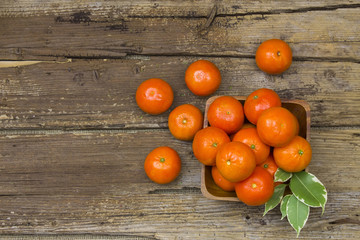 Fototapeta na wymiar fresh tangerines in a bowl on wooden background