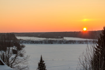 snow-covered field in the rays of the setting sun
