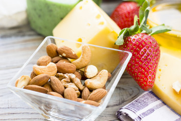 Snacks with wine - various types of cheeses, figs, nuts, honey, grapes on a blue wooden background