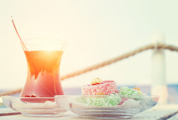 Cup of black Turkish tea and traditional asian sweets.