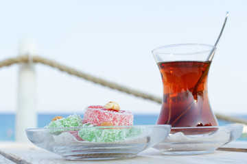 Cup of black Turkish tea and traditional asian sweets.